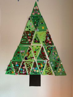 a paper christmas tree hanging on the wall