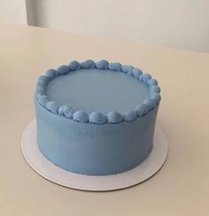 a blue frosted cake sitting on top of a white plate