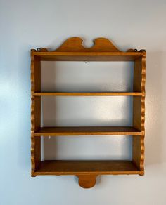 a wooden shelf mounted to the wall with two shelves on each side and one above it