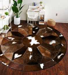 a living room with a cowhide rug on the floor next to a white chair