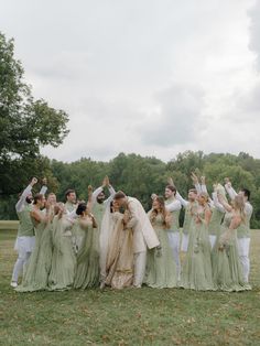 a group of people standing next to each other on top of a lush green field