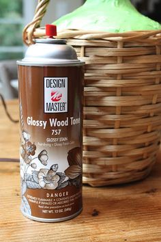 a can of glassy wood tone paint sitting next to a basket on a table