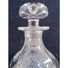 a clear glass bottle with a flower on the top is sitting on a black surface