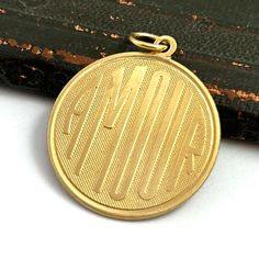 a close up of a gold medal on a white surface with an old book in the background