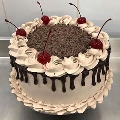 a chocolate cake with cherries and whipped cream