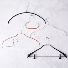 three clothes hangers on a marble surface