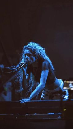 a woman standing on top of a stage holding a microphone