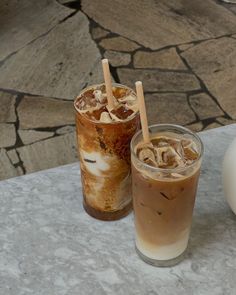 two iced drinks sitting next to each other on a table