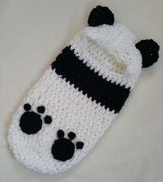 a crocheted panda bear hat laying on top of a bed