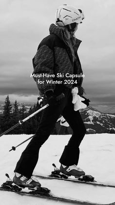 a man riding skis on top of a snow covered slope with ski poles in his hand