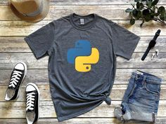 a t - shirt with a yellow and blue snake on it next to some jeans