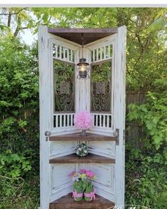 an old door is turned into a potted plant stand with flowers on top and the bottom shelf