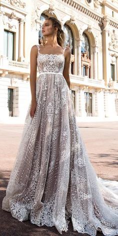 a woman standing in front of a building wearing a wedding dress