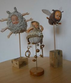 three small figurines sitting on top of a wooden table