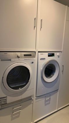 a washer and dryer in a room next to each other with white cabinets