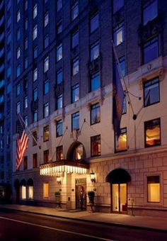 the hotel is lit up at night in front of an american flag on the building