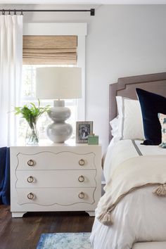 a white dresser sitting next to a bed in a bedroom on pinterest board