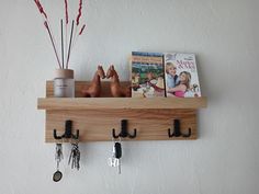 a wooden shelf with hooks and key holders on it