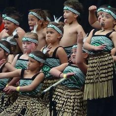 a group of young boys and girls dressed in native garb, standing next to each other