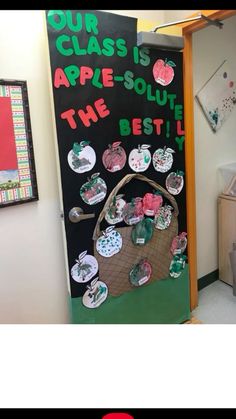 a classroom door decorated with apple themed decorations