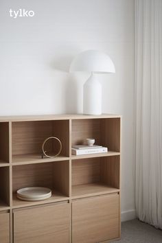 a white lamp sitting on top of a wooden shelf