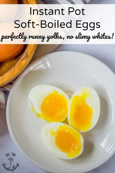 three hard boiled eggs on a white plate next to an orange and some other food