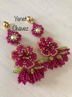 some pink and green beaded flowers on a white table with the words vannet chaez