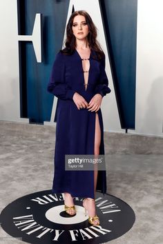 an image of a woman in a blue dress posing for the camera on a carpet