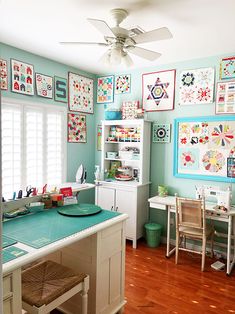 a room filled with lots of pictures on the wall next to a table and chairs