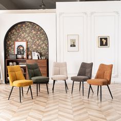 four chairs are lined up in a room with wallpaper and pictures on the walls