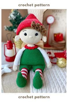 a crocheted doll sitting on top of a bed next to a christmas tree