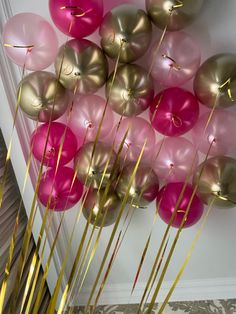 there are many pink and gold balloons on the wall