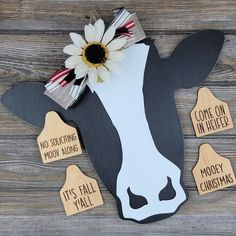 a cow with a flower on it's head and some tags attached to it