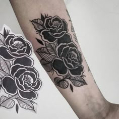 a black and white rose tattoo on the arm