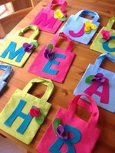 colorful handmade bags with flowers on them sitting on a table