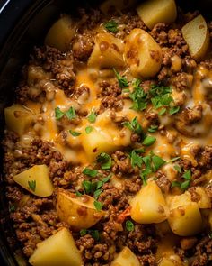 a crock pot filled with ground beef and potatoes, garnished with parsley