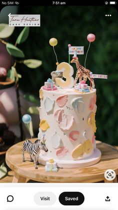 a birthday cake decorated with animals and balloons