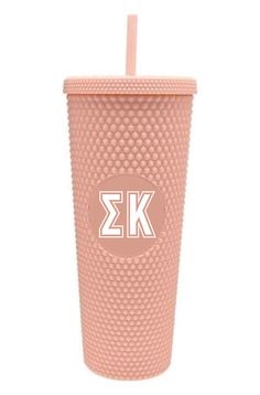 a pink tumbler cup with the letter k on it and a straw in front