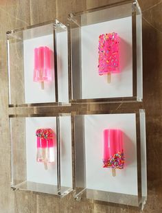 three ice cream popsicles with sprinkles on them in clear acrylic boxes