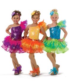 three girls in colorful dresses posing for the camera