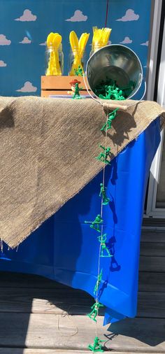 a blue table with some yellow flowers on it and a burlocked cloth