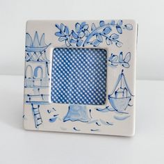 a blue and white photo frame sitting on top of a table