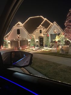 christmas lights decorate houses and trees in the driveway