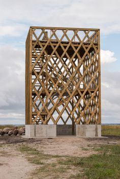 a wooden structure sitting on top of a dirt field