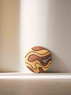 a wooden object sitting on top of a white floor next to a wall with light coming through it