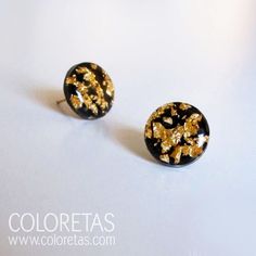 two black and gold earrings on a white surface with the words coloretas written below them