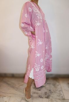 Exquisite pure silk Chikankari dress in a lovely cherry blossom shade. Features a pleated yoke with a split neckline and elegant poet sleeves adorned with cuffs. The 47/48-inch length is complemented by short side slits for ease of movement. Vintage Chikankari embroidery adds timeless charm, while convenient pockets offer practicality. A perfect blend of traditional craftsmanship and modern comfort. Sizes : S - fits bust 34 M - fits bust 36 L - fits bust 38 XL - fits bust 40 0X - fits bust 42 Prewashed. Preshrunk. Wash - All silks are to be dry cleaned. However as an option, one also bucket wash them separately in light detergent and cold water. Line Dry, Light iron for best results. Elegant Pink Summer Kurta, Elegant Summer Kurta With Set-in Sleeves, Straight Kurta With Set-in Sleeves For Spring, Pink Long Sleeve Dress With Chikankari Embroidery, Pink Long Sleeve Kurta For Spring, Long Sleeve Pink Kurta For Spring, Traditional Long Sleeve Midi Dress For Spring, Traditional Spring Tunic Midi Dress, Spring Long Sleeve Kurta With Pintucks