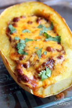 a cheesy baked dish is sitting on a glass platter, ready to be eaten