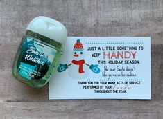 a bottle of hand sanitizer sitting next to a card with the message, just a little something to keep handy this holiday season