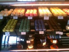 a display case filled with lots of different types of cakes and cupcakes next to each other